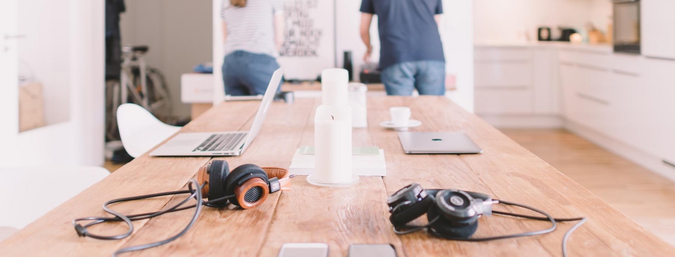 people in smart home with laptops and smartphones