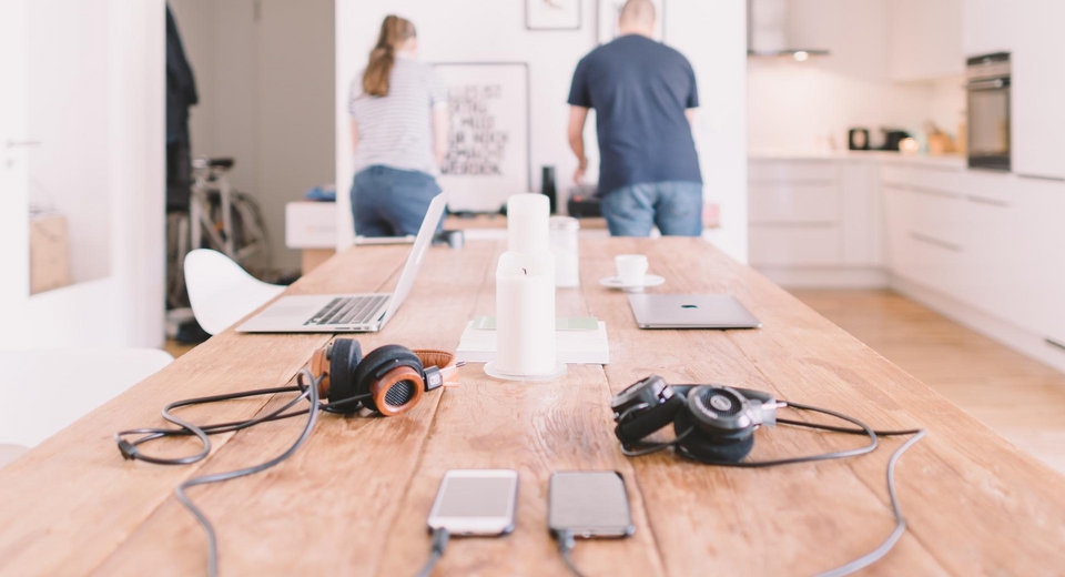 people in smart home with laptops and smartphones